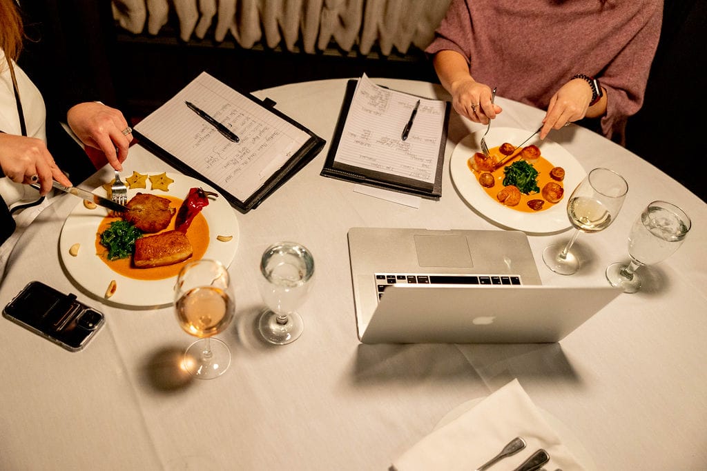 Eating with a laptop and notebooks in a business meeting